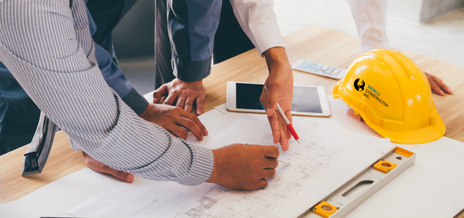 A group of people reviewing blueprints at a table.
